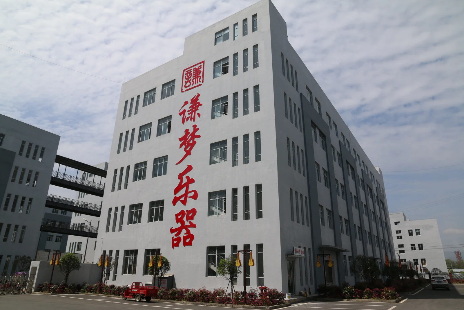 贵州谦梦乐器制造有限公司工厂外观，楼体标有谦梦乐器