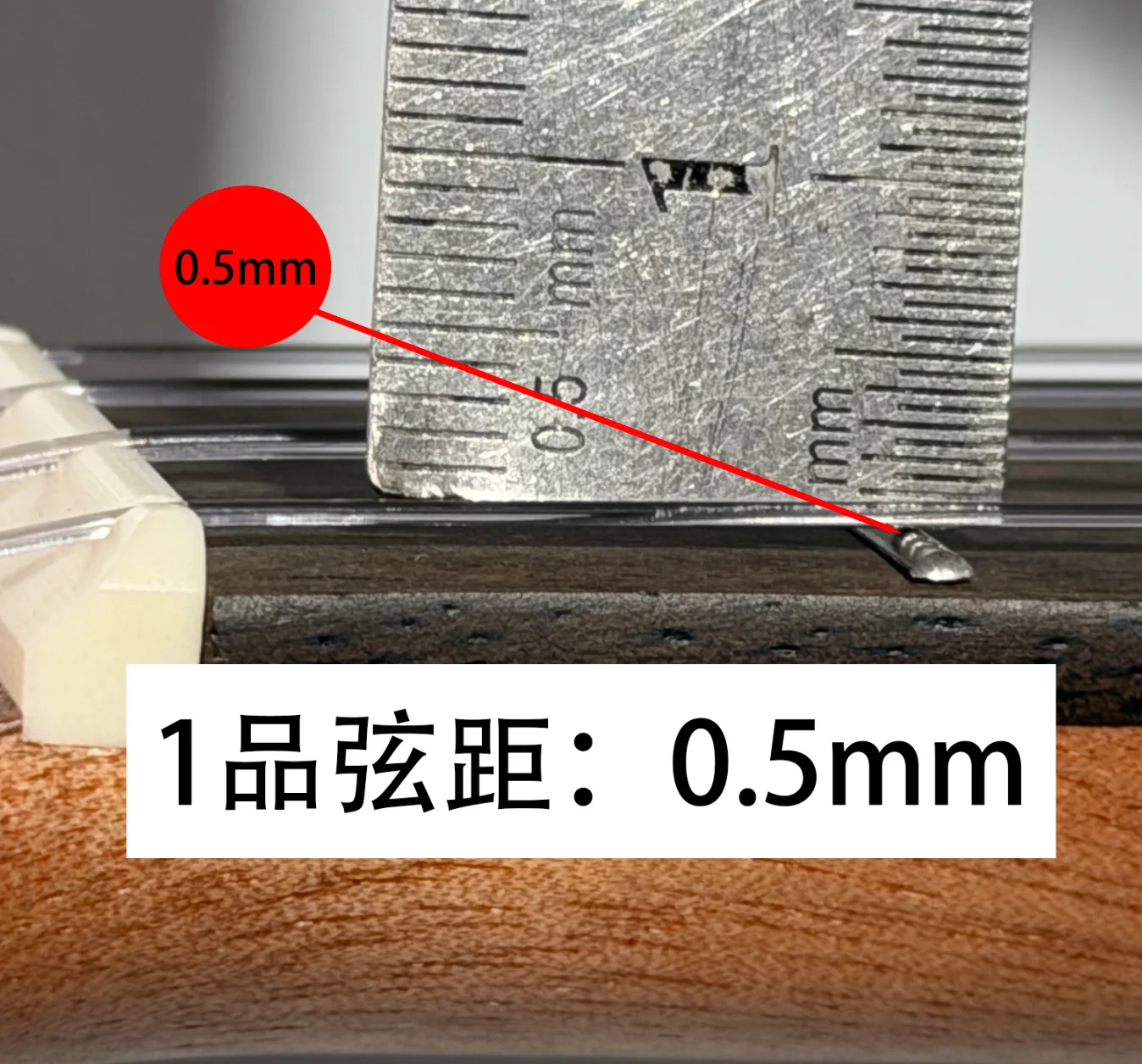 弦距测量示意：图中第一品处约0.5mm，仅为该琴示例，不代表所有琴的统一调校标准。